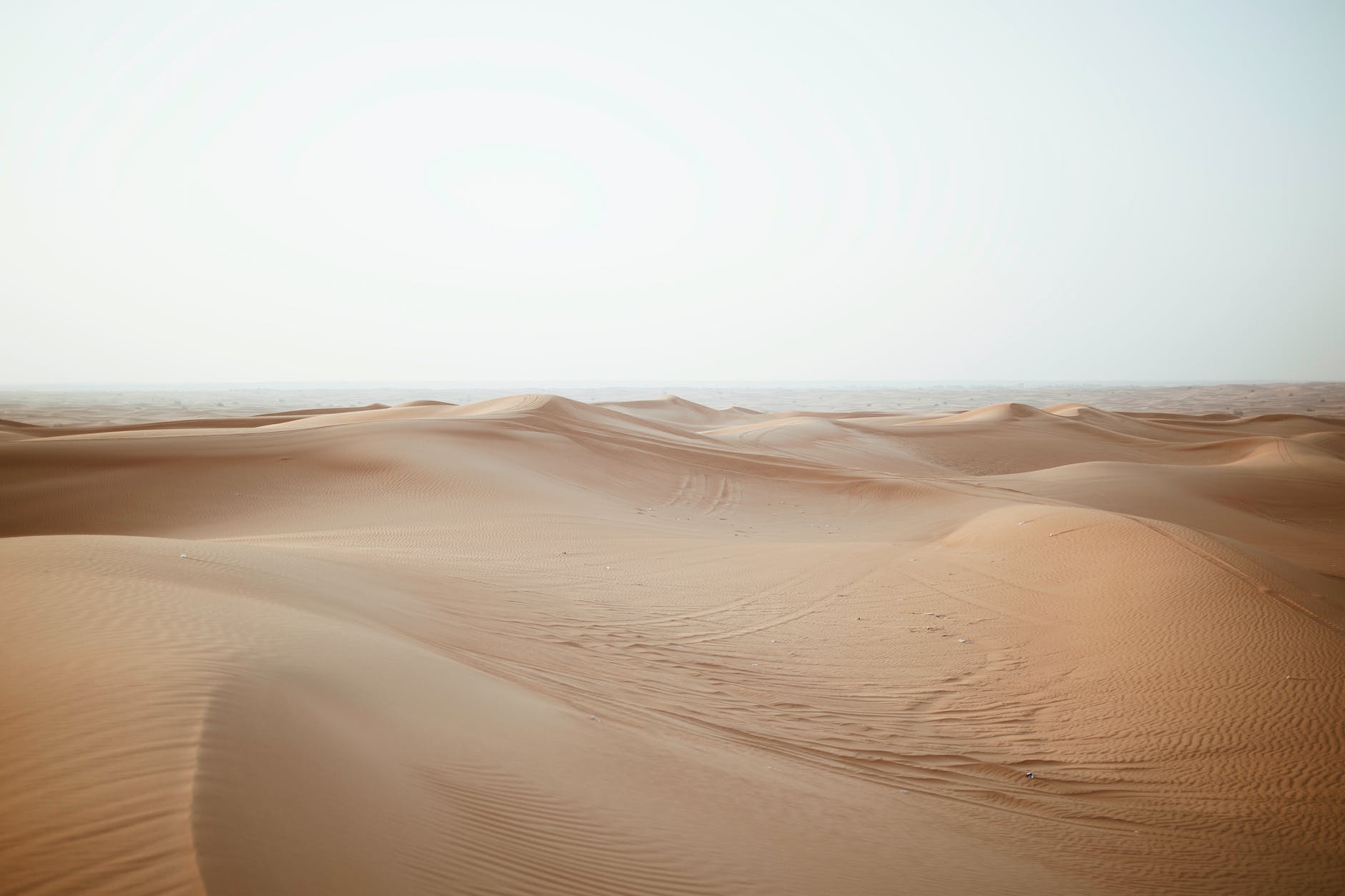 sand dunes in desert under cloudy sky